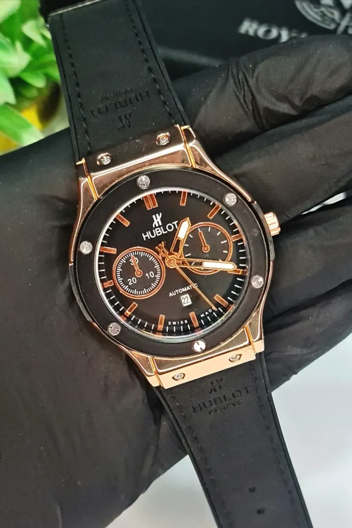 Hublot black and rose gold quartz watch with black dial, automatic movement, and black rubber strap for men.