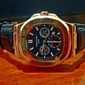 Patek Philippe Grand Complications black dial luxury watch with rose gold and stainless steel case, leather strap, and advanced moonphase and calendar functions.